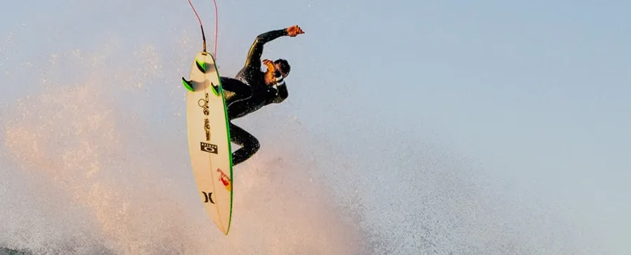 Surfista en un aéreo, con las quillas de la tabla a la vista
